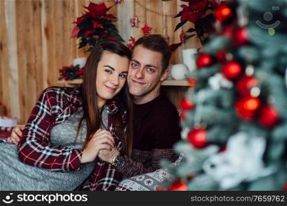 a guy and a girl celebrate the new year together  in a warm atmosphere and give each other gifts