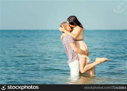 a guy and a girl walk along the seashore, swim in the water