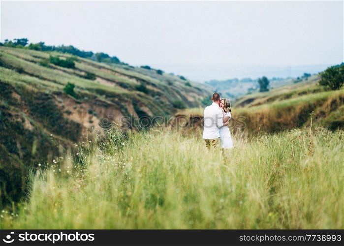 a guy with a girl in light clothes on the background of a green canyon of erosion of the earth