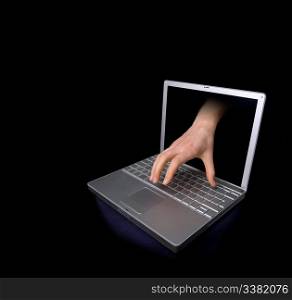 A hacker concept image of a hand coming through the computer.