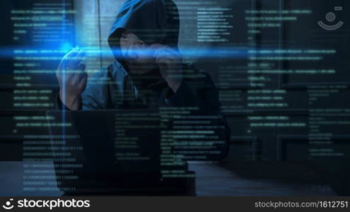 A Hacker is using laptop computer to steal data in the night 