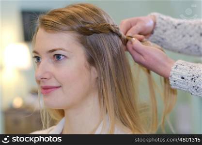 a hairdresser braiding a client