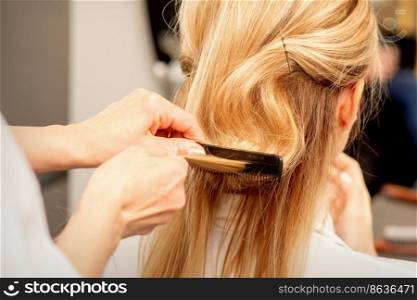 A hairdresser is combing female hairstyling in a hairdressing beauty salon. A hairdresser is combing female hairstyling in a hairdressing beauty salon.