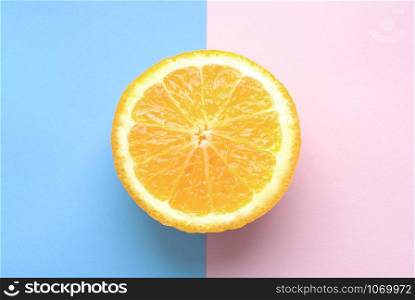 A half lemon piece on a pink and blue background.