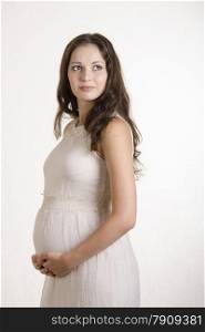 A half-length portrait of a pregnant girl in a beige tight dress