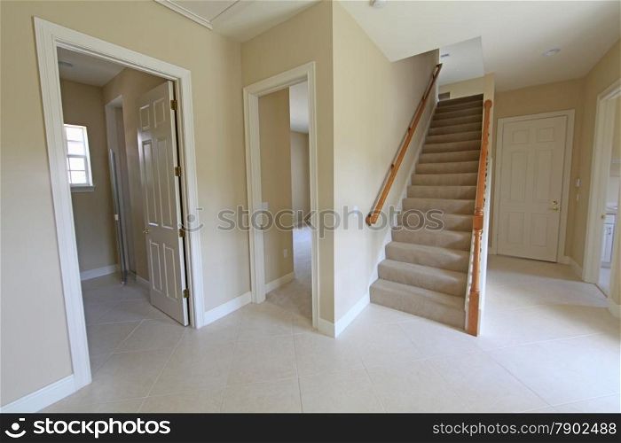 A hallway with stairs and doorways in a home