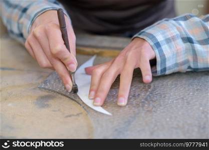 a hand cutting a pattern