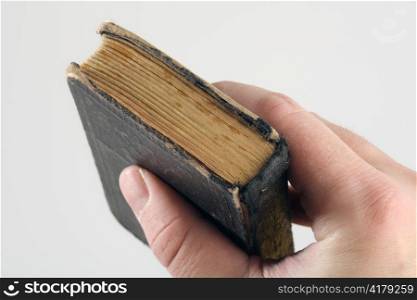 A hand grabbing an old small book