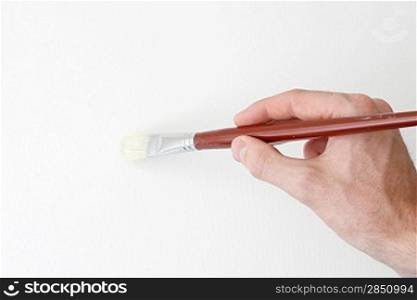 A hand holding a brush on white
