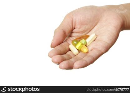 A hand holding multiple vitamins