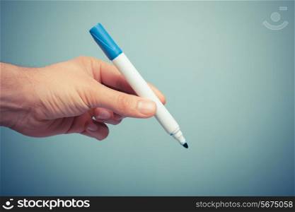 A hand is holding a blue marker