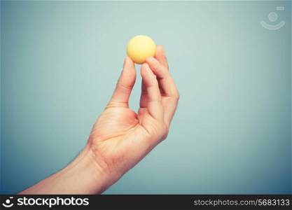 A hand is holding a small ball