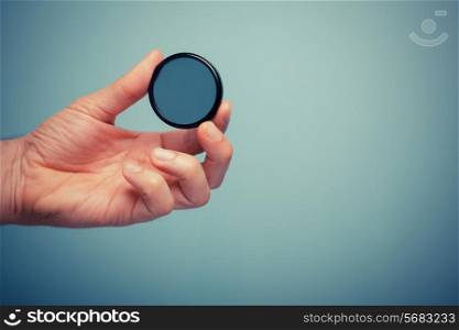 A hand is holding circular polarizer filter