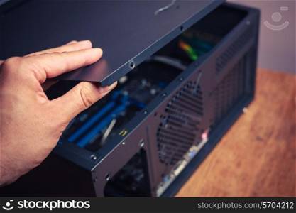 A hand is opening up a computer case