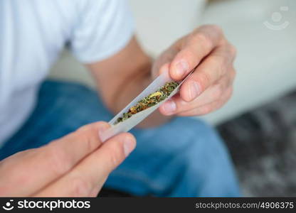 a hand rolling a cigarette