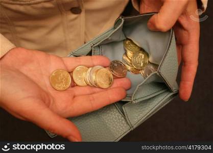 . a hand with a wallet and a few coins. inflation and debt