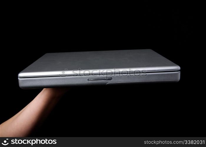 A handholding a small laptop computer with a blank screen.