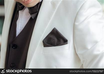 A handkerchief in a white suit of a man who is about to be the bridegroom.