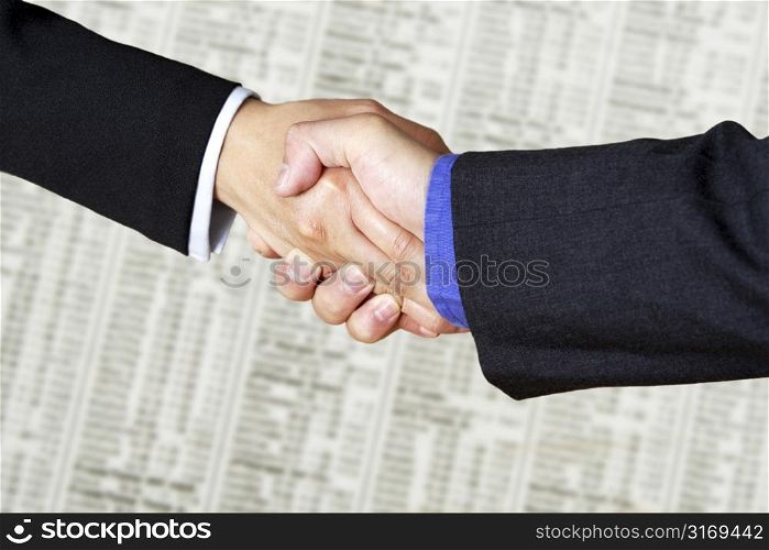 A handshake between two businessmen over financial figures