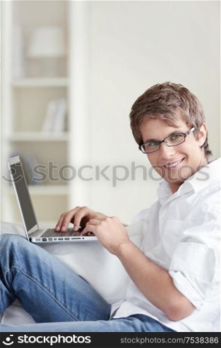 A handsome man with laptop at home