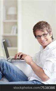 A handsome man with laptop at home