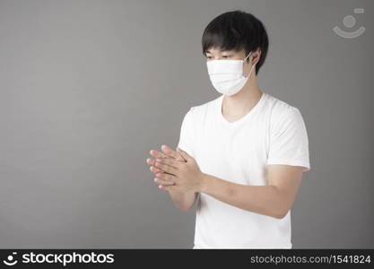 A handsome man with surgical mask is using alcohol hand sanitizer