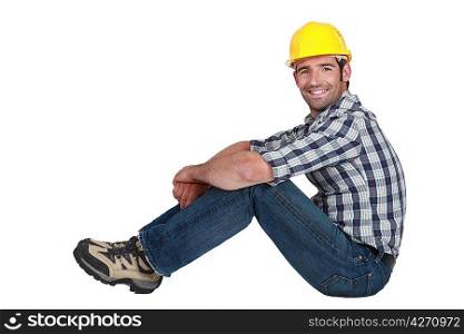 A handsome manual worker seated.