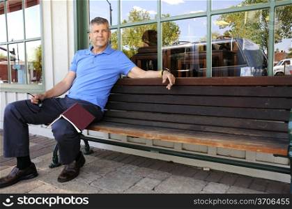 A Handsome middle aged man sitting on a bench