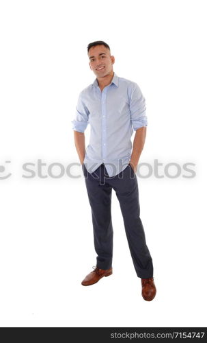 A handsome young east Indian man standing in a blue shirt with his hands in his pocket, smiling, isolated for white background