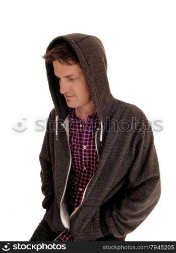 A handsome young man sitting with a hoody over his head lookingdown, isolated for white background.