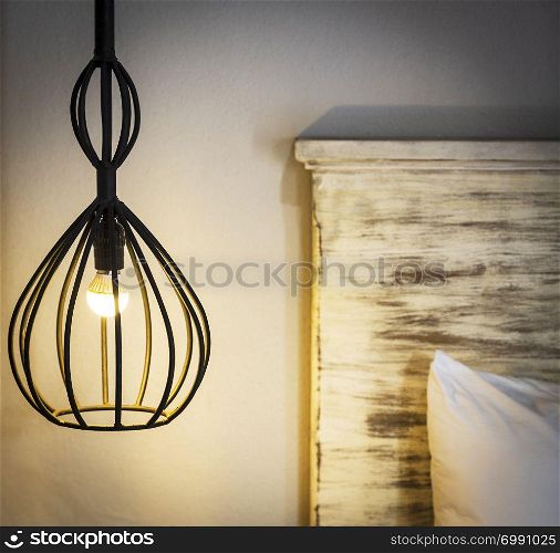 A hanging bedside lamp made from wrought iron