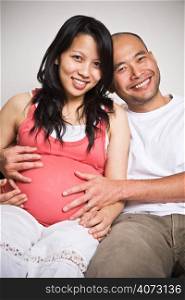 A happy asian couple expecting for their unborn baby