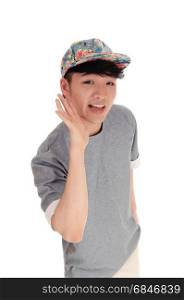 A happy Asian teenager in a closeup image holding his hand on his facewearing a cap on his head, isolated for white background.