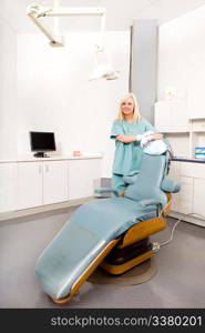 A happy assistant / hygienist standing by a dental chair
