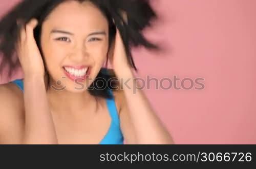 A happy beautiful girl giving two thumbs up, isolated on pink