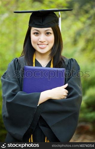 A happy beautiful graduation girl holding her diploma