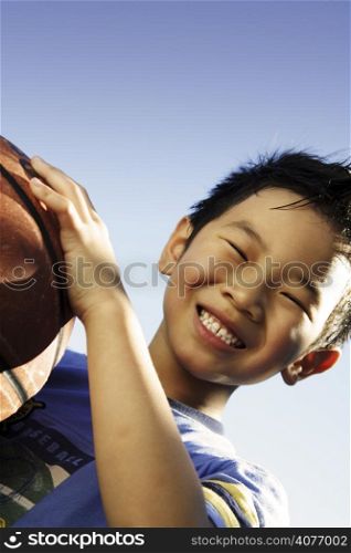 A happy boy holding a basketball