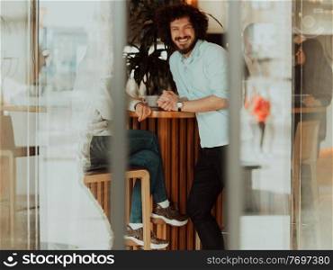 A happy business couple is drinking coffee and smiling while sitting at the cafe. the couple rest in a cafe after a hard day’s work