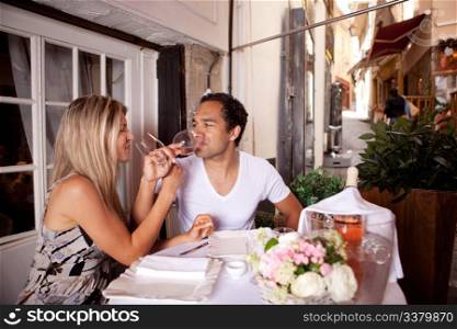 A happy couple drinking wine in a cafe in France