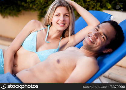 A happy couple on beach chairs, looking at the camera