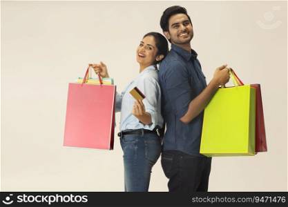 A HAPPY COUPLE POSING TOGETHER WITH SHOPPING BAGS IN HAND