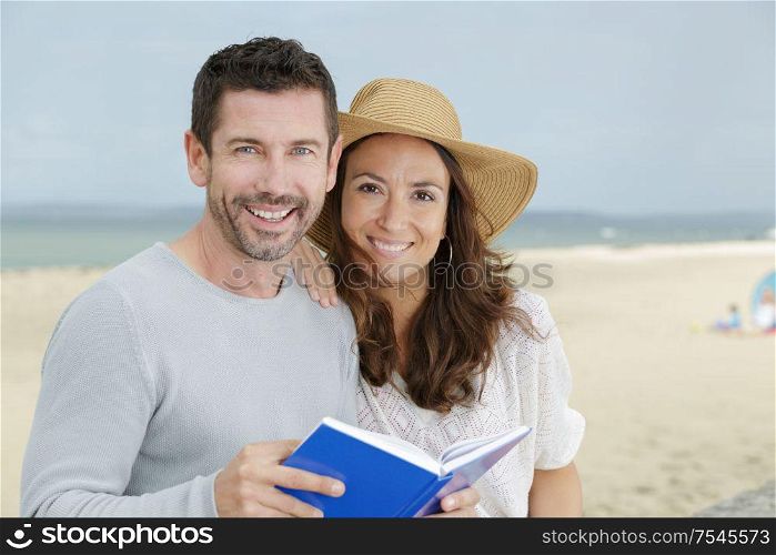 a happy couple reading a book