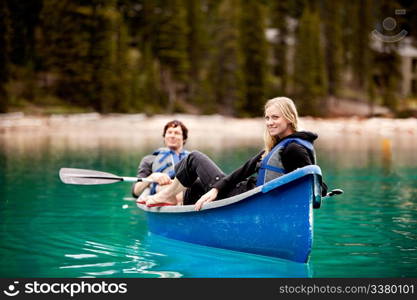 A happy couple relaxing in a canoe on a glacial lake