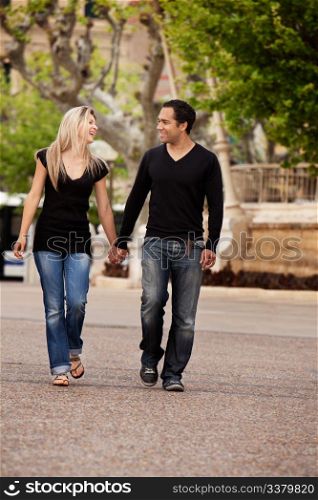 A happy couple walking in the city looking at each other