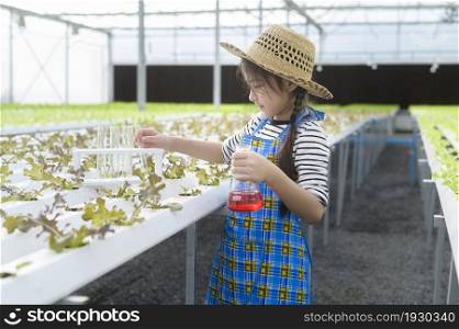 A happy cute girl learning and studying in hydroponic greenhouse farm, education and scientist concept. Happy cute girl learning and studying in hydroponic greenhouse farm, education and scientist concept