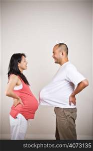 A happy expecting pregnant asian couple facing each other