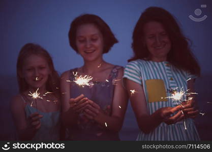 a happy family. girls holds bengal lights - happy holidays