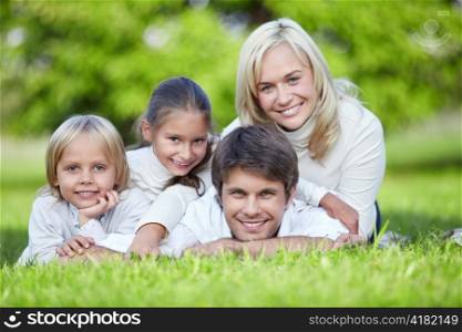 A happy family lying on the grass in the park