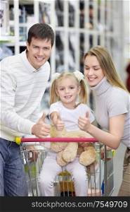 A happy family shows thumbs up at the store