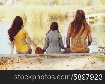 A happy family sitting by the lake